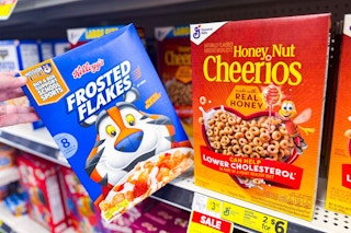 hand holding box of frosted flakes next to honey nut cheerios