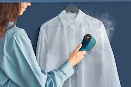 woman using steamer on dress shirt
