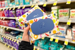 person holding 2 packs of honest wipes