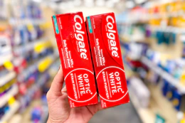 hand holding colgate optic white toothpaste in cvs
