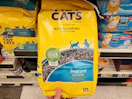 hand holding a bag of purina tidy cats litter