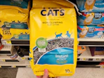hand holding a bag of purina tidy cats litter