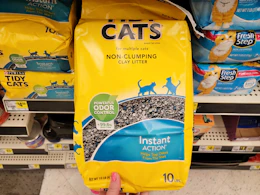 hand holding a bag of purina tidy cats litter
