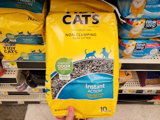 hand holding a bag of purina tidy cats litter