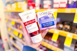 person holding loreal cleanser and moisturizer