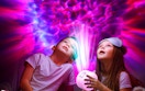 two kids holding a galaxy projector
