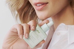 a woman holding a divi scalp serum