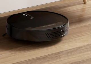 a robot vacuum under a table on the floor