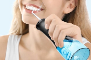woman using water flosser