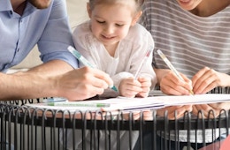 a family coloring with markers at a table
