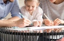 a family coloring with markers at a table
