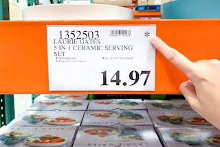 someone pointing to an asterisk symbol on a costco price sign