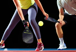 people playing with the pickleball paddles and ball