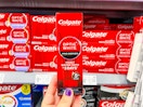 hand holding a box of Colgate-optic-white-pro-series-toothpaste in walmart aisle