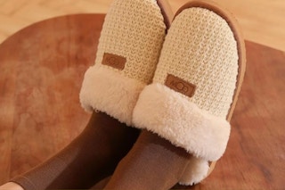 Woman wearing the OOW Cozy House Slippers sitting in a chair.