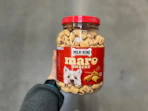 a person holding a jar of dog treats