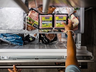 person opening freezer and grabbing butcherbox meat