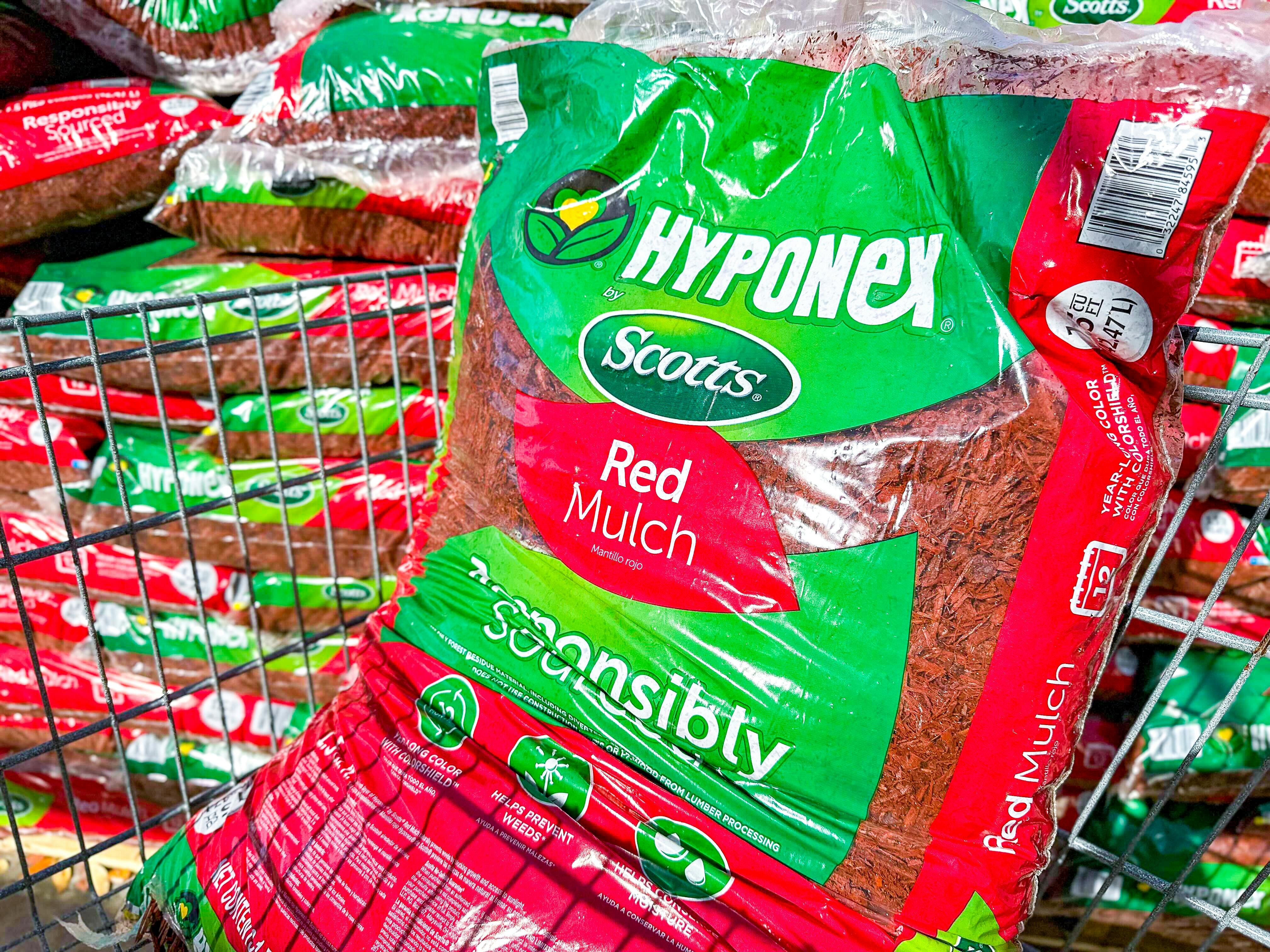 A bag of red Scotts Hyponex mulch in Walmart shopping cart