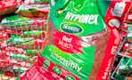 A bag of red Scotts Hyponex mulch in Walmart shopping cart