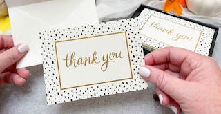 thank you note being held and about to be put into an envelope