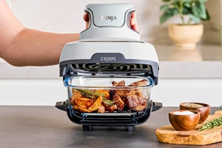 Lifestyle image of the Ninja Crispi 3-in-1 Portable Glass Air Fryer Cooking System being used in a kitchen setting