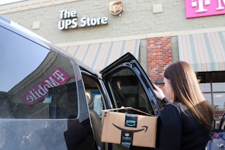 a person getting a box out of a car outside ups store