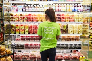 Instacart shopper inside a grocery store looking at pre-cut fruit