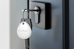 FLYRUIT Air Tracker Tags-4 Pack on a set of keys in a door lock.