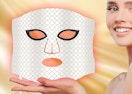 a person holding a red light face mask 