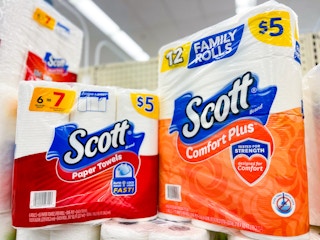 pack of paper towels and toilet paper on store shelf in paper goods section