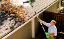 a person using a leaf blower to clear leaves from a roof