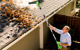a person using a leaf blower to clear leaves from a roof
