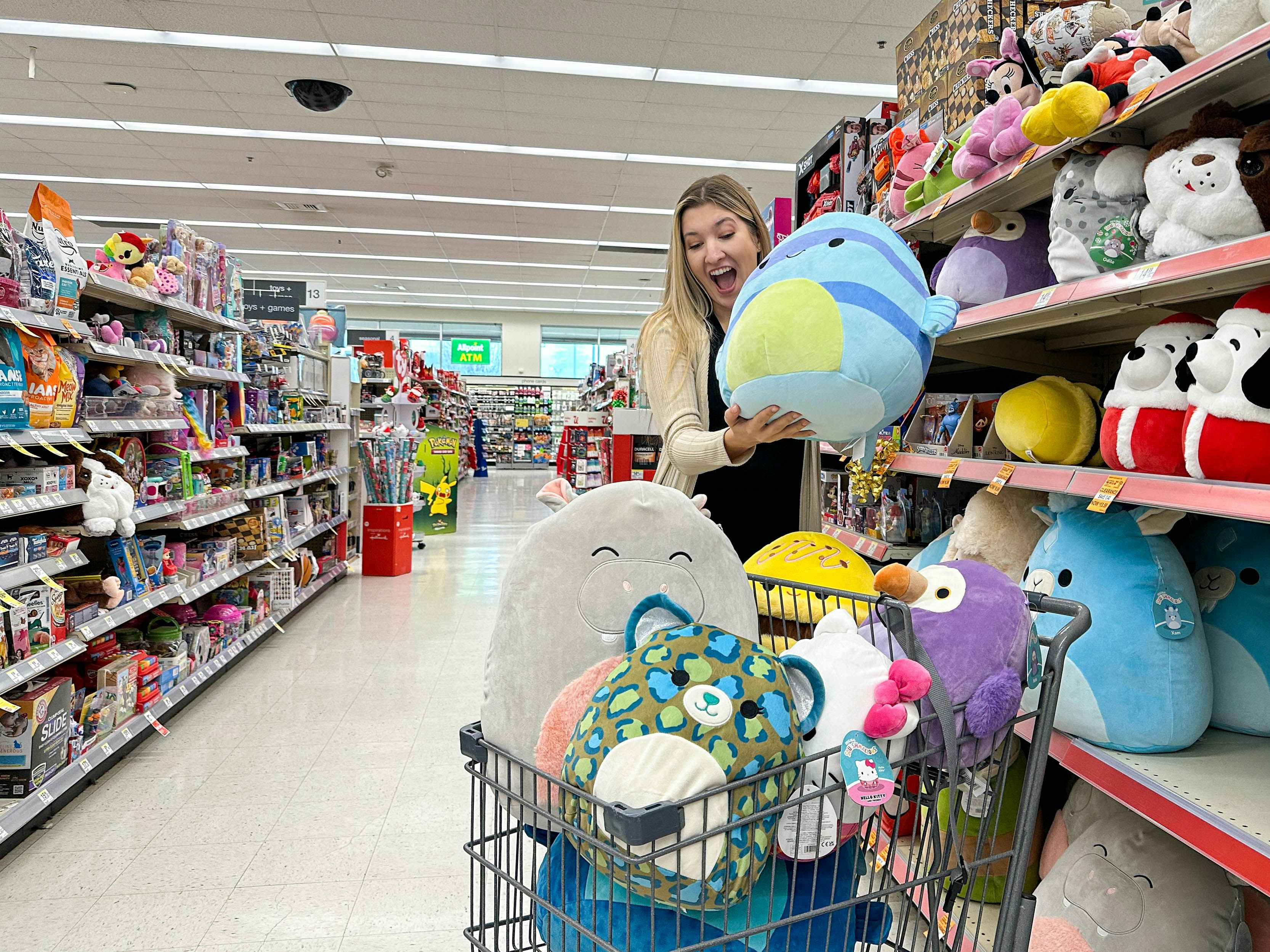 a woman throwing a squishmellow in walgreens cart