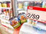 hand holding 2 ben & jerry's ice cream pints in front of target sale sign