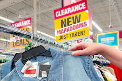 a woman's hand taking a clearance jacket off of a rack at Burlington