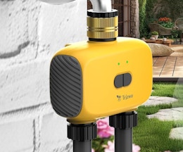 a yellow sprinkler timer on a water faucet outside