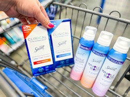 hand holding two boxes of secret clinical deodorant with three whole body sprays in walmart cart