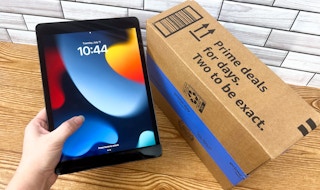 Someone holding an iPad next to an Amazon Prime Day box