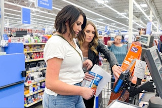 Two people at the Walmart checkout making a purchase