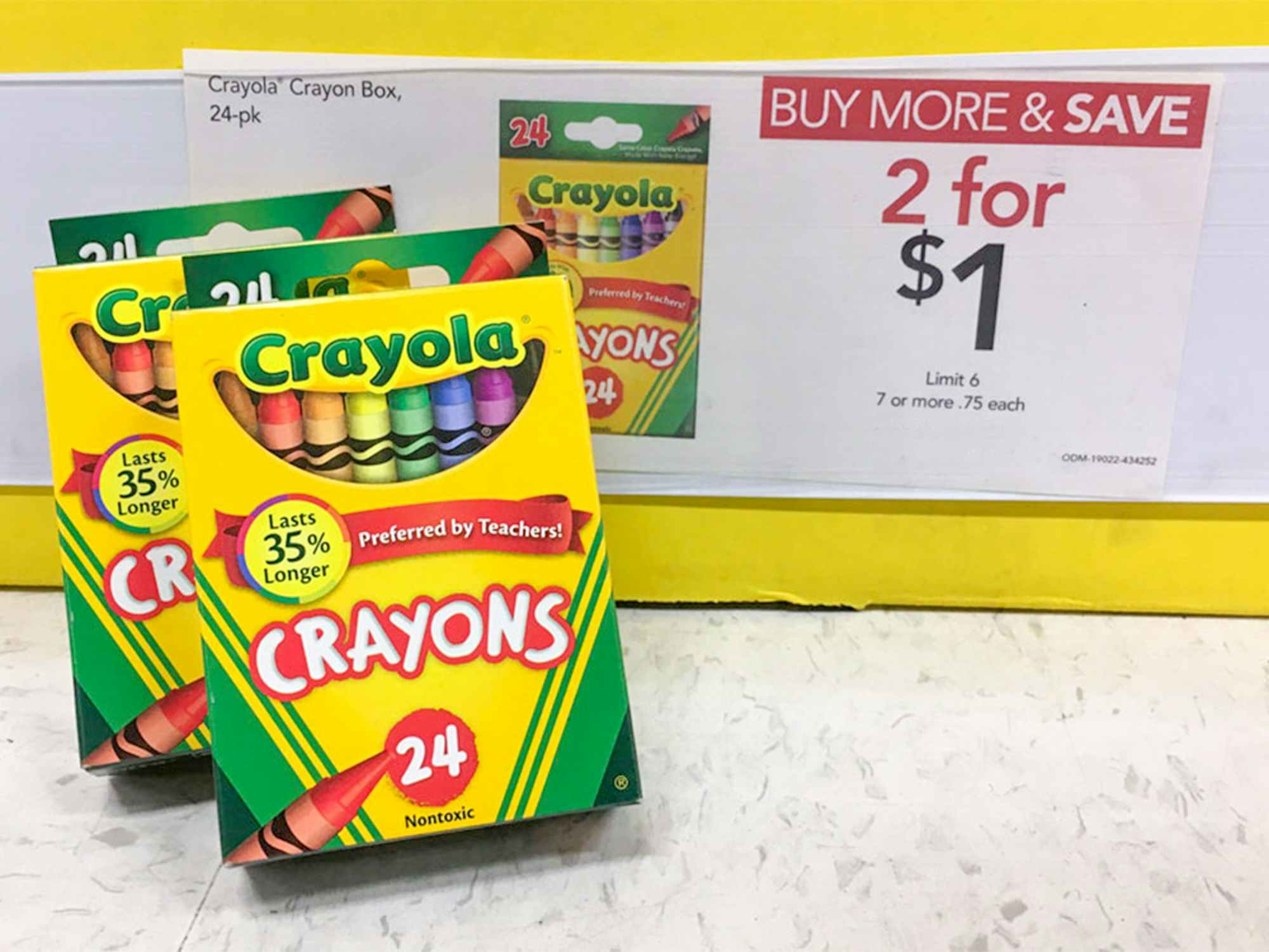 Boxes of Crayola crayons next to a sale sign for 2 for $1 at Office Depot