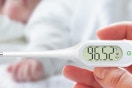 a digital thermometer in front of a baby