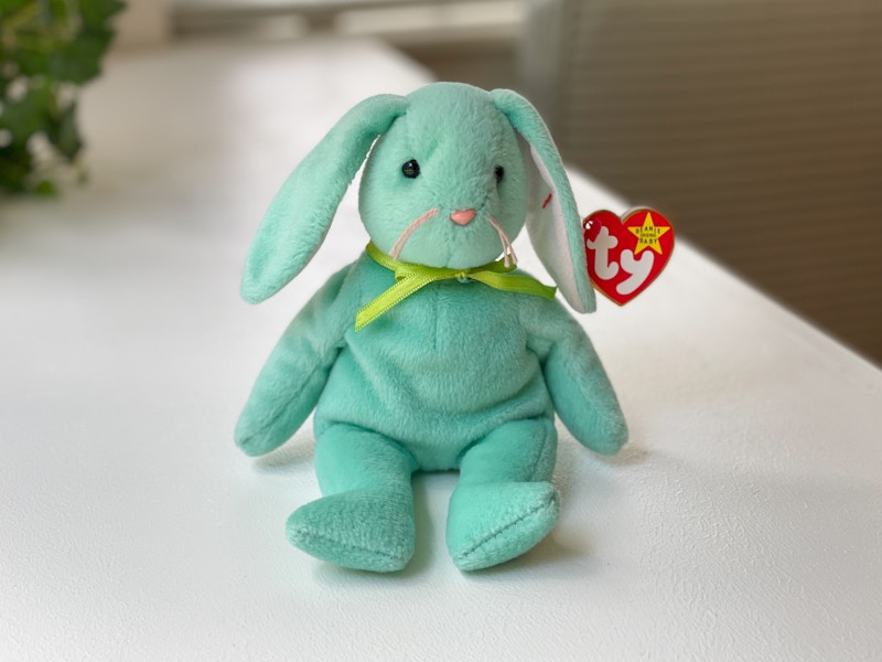 A Hippity the rabbit beanie baby sitting on a white table.