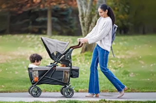 Lifestyle image of mom pushing Summer Infant Wagon with two small children inside outdoors