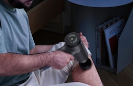 a person using a massage gun on their leg 