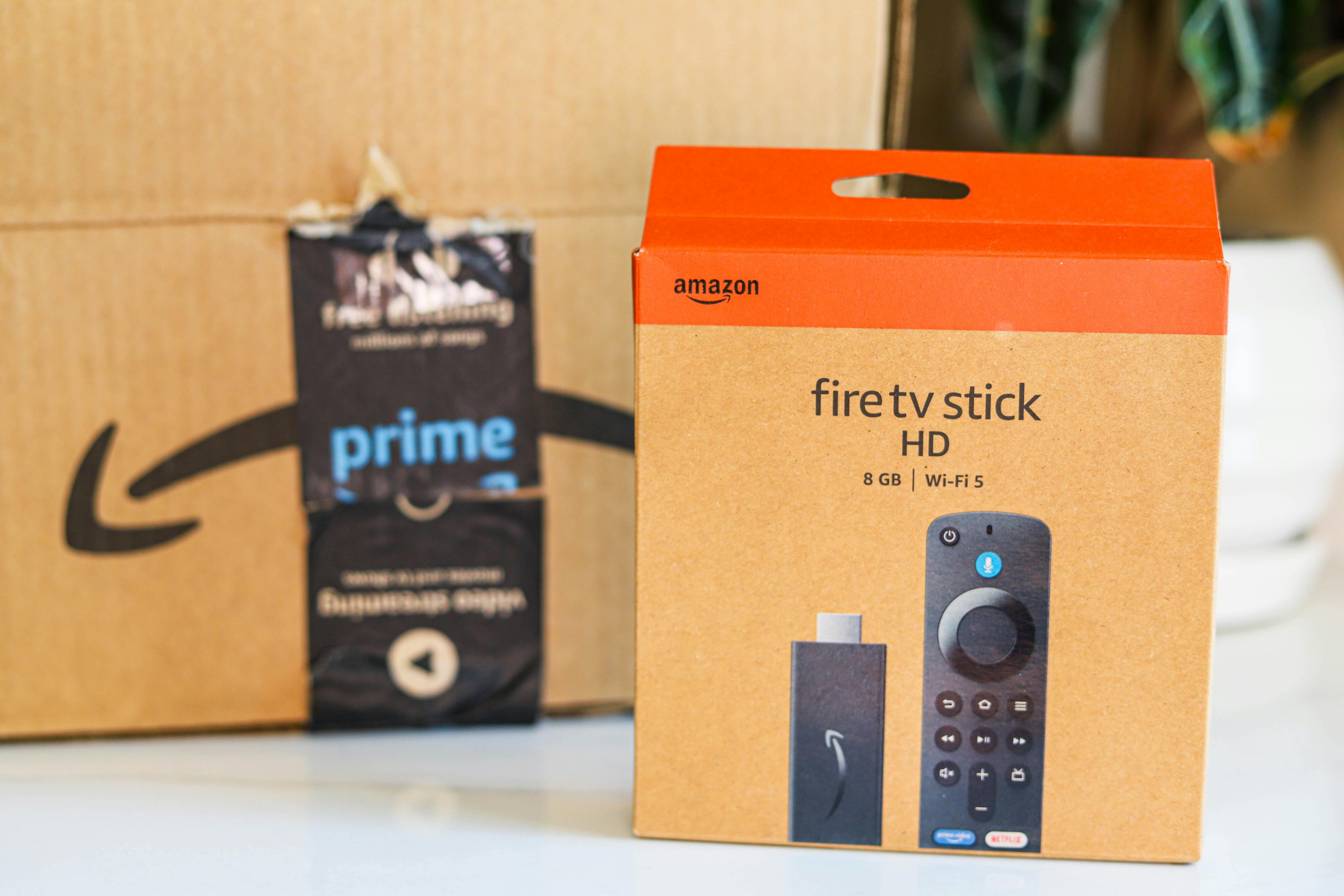 an amazon fire tv stick box sitting in front of an Amazon box on counter