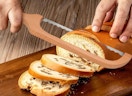 a hand slicing a loaf of bread with a bread knife 