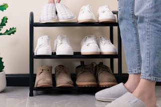woman placing shoes on rack