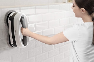 A woman cleaning a wall with the Samsung Jetbot