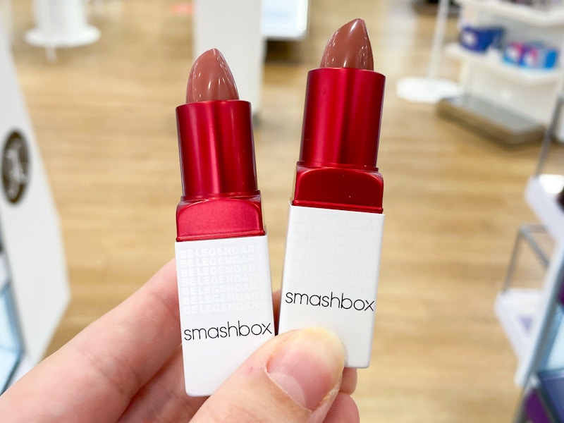 person holding two smashbox prime plush lipsticks in ulta store