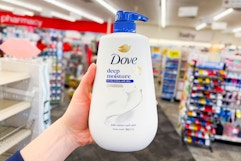 hand holding large dove body wash in a store aisle